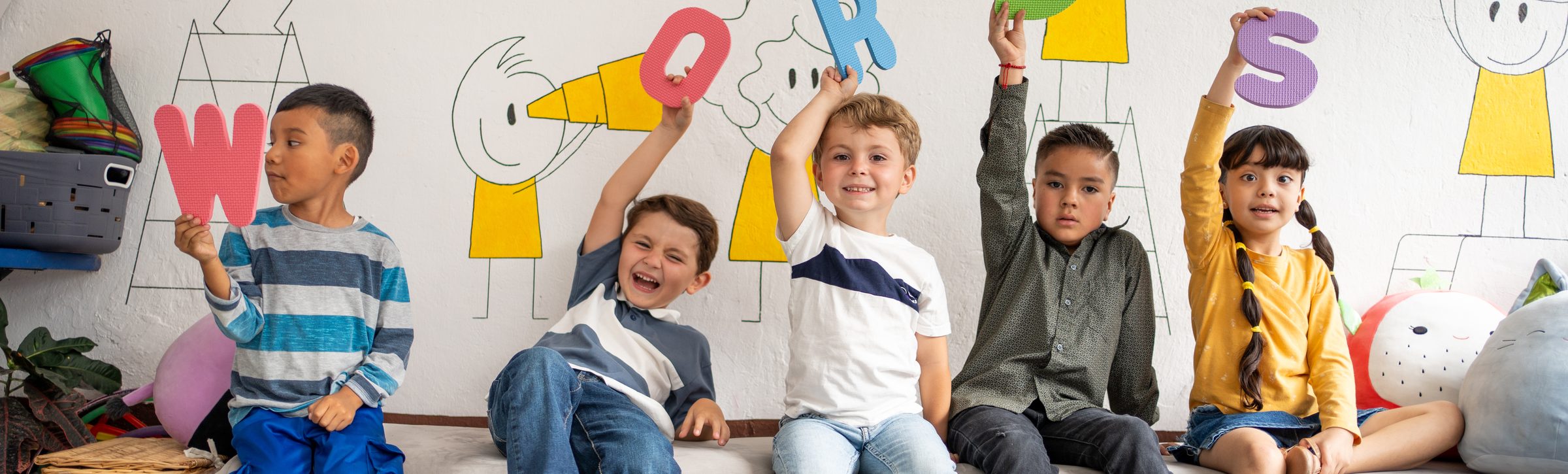 Bambini che giocano con le lettere colorate della parola "words"